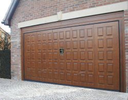 Remote control garage door by Silvelox with pedestrian door available in oak, larch or mahogany